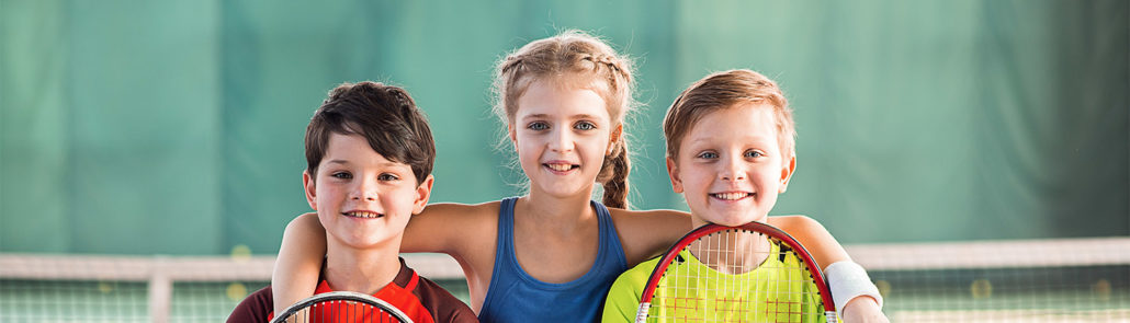 Cheerful kids having fun on tennis court